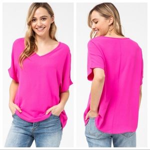 Solid v-neck top featuring rounded hem detail.